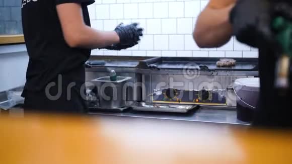 厨师在餐厅厨房的烤炉上煎汉堡4k视频的预览图