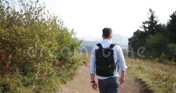 孤独地走在山里一个人走在路上走在一座山上前面有一片壮丽的风景他看着自己视频的预览图