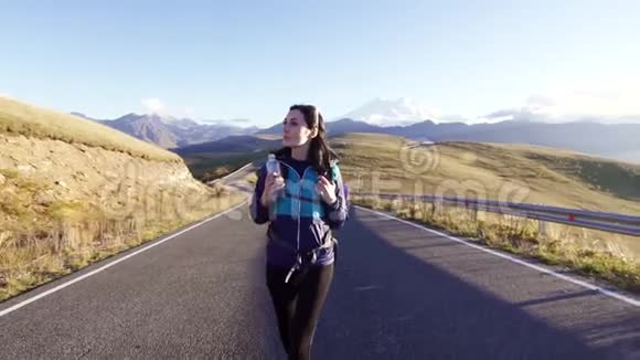 背着背包的女游客走在去山区的路上视频的预览图