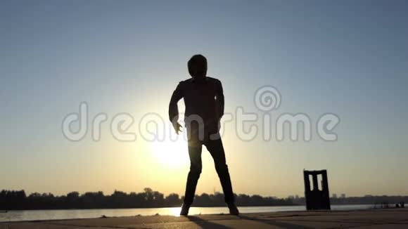 太阳落山时活跃的人跳上了斯洛莫的河岸视频的预览图