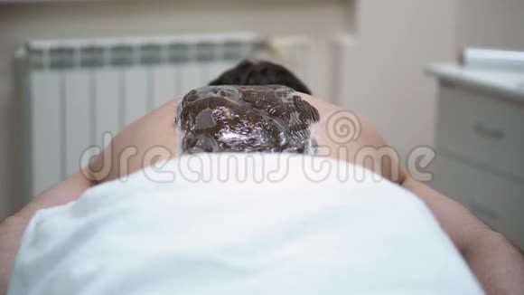 巧克力裹体治疗人背部特写在水疗中心休息视频的预览图