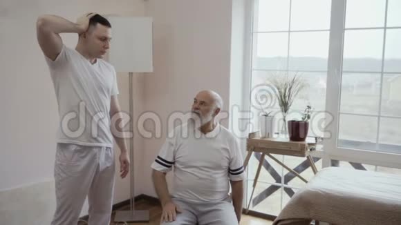 治疗师向老人展示一项体育锻炼视频的预览图