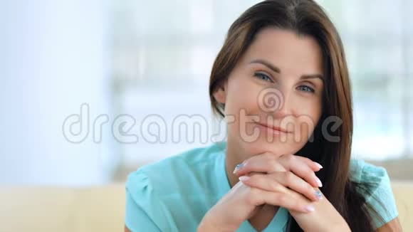 时髦快乐的年轻女人坐在沙发上美容时尚肖像视频的预览图