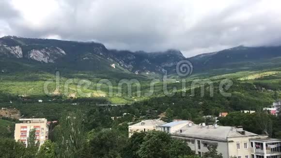 时间流逝克里米亚的村庄古尔祖夫在雨前的背景下山和云很快穿过天空视频的预览图