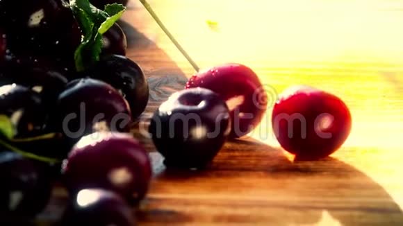 阳光明媚的一天一堆湿甜的樱桃放在木桌上视频的预览图