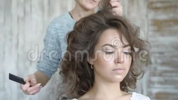 化妆师和模特一起工作理发师做模特的发型发型师在视频的预览图