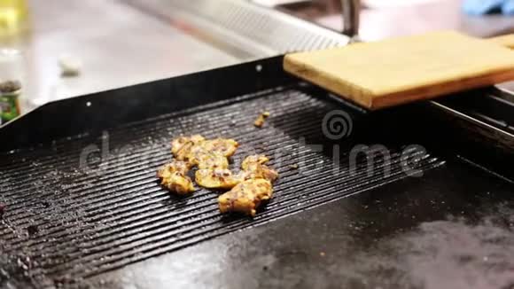 将切好的鸡肉在炒制表面上进行特写烤制然后再将其翻转视频的预览图