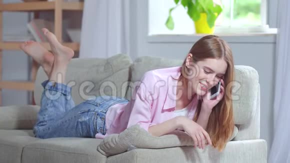 看年轻女孩在电话上微笑着说话视频的预览图