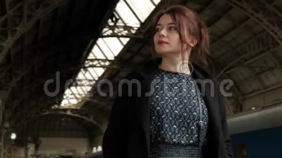 火车站穿着黑色外套的漂亮中年黑发女人视频的预览图