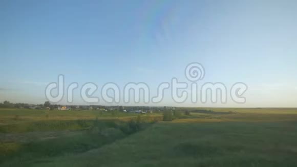 从一辆高速行驶的汽车上拍摄的阳光下的田野视频的预览图