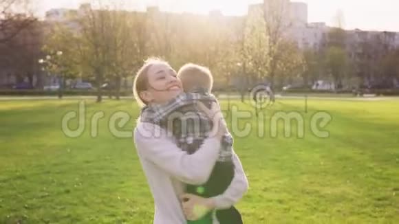 妈妈在城市公园日落时拥抱小儿子视频的预览图