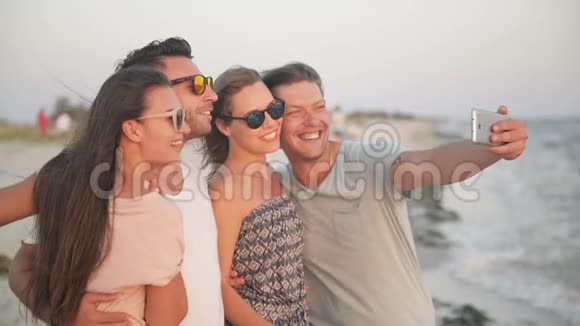 积极四人利用智能手机在暑假共同度过的海滩上自拍视频的预览图
