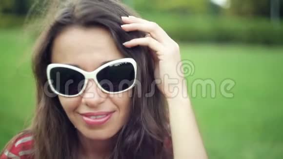 戴太阳镜的女人在夏天的田野里微笑美容视频的预览图