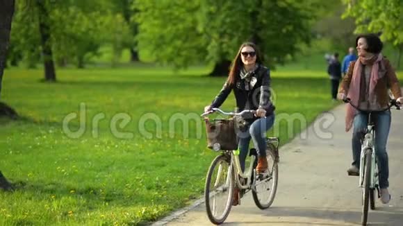 城市自行车在两个美丽的不伦特公园与迷人的微笑第一个女人有短卷发另一个视频的预览图