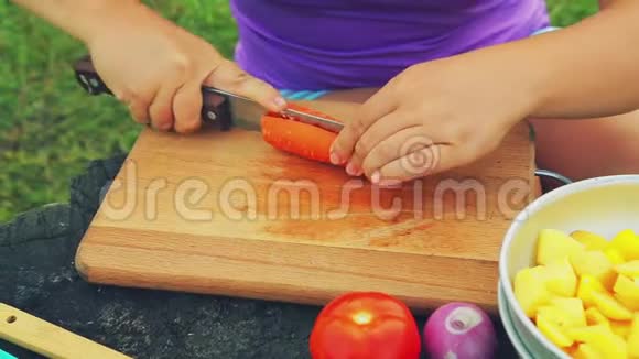 女人用刀子在木板上切胡萝卜视频的预览图