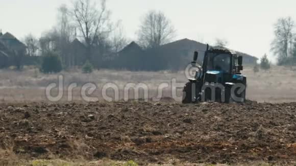 拖拉机蓝色的大黑色车轮和强大的轮沉重的犁黑暗肥沃的土壤农业视频的预览图