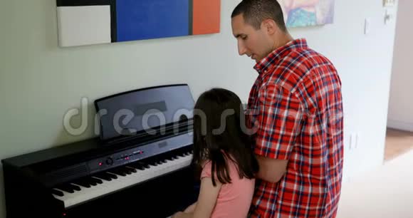 父亲教女儿弹钢琴视频的预览图