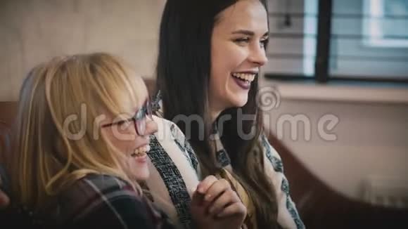 美女在电视上看浪漫喜剧年轻的白人女孩看情节剧电影吃爆米花母鸡派对4K视频的预览图