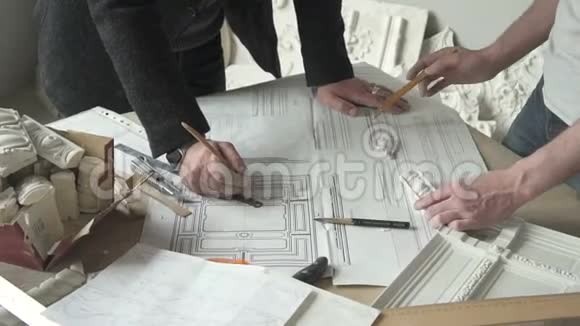 建筑师在现代办公室的桌子上用素描和石膏细节进行修复视频的预览图