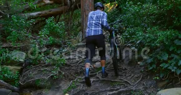 男子骑着自行车在森林里散步视频的预览图