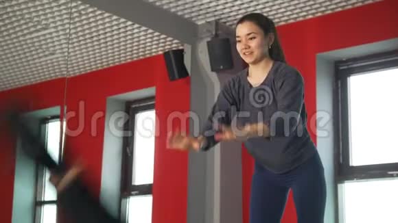 女教练在健身班帮助男子进行健脚练习视频的预览图
