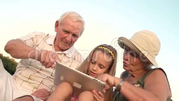 祖父母和孙女玩电脑平板电脑视频的预览图
