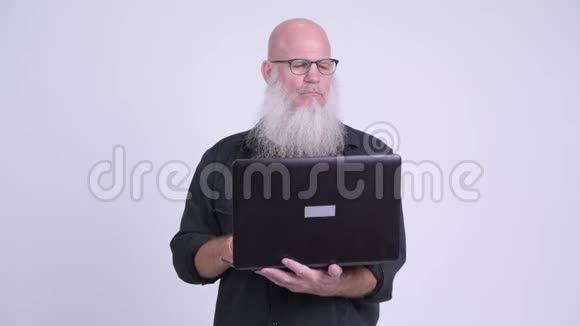 快乐成熟的秃头男人用笔记本电脑视频的预览图
