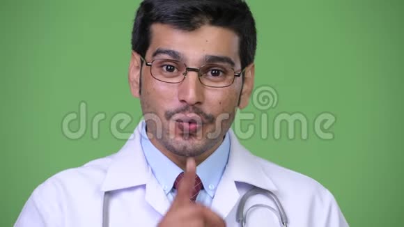 年轻英俊的波斯男医生手指着嘴唇视频的预览图