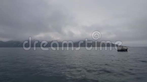 在雪山背景下漂浮在水中的大型海上船桶视频的预览图