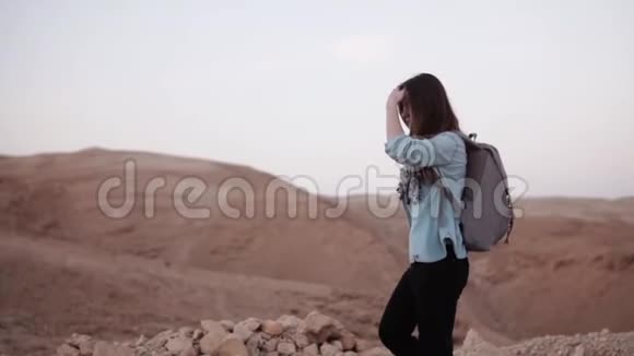 高加索女人在沙漠徒步旅行慢动作旅游女孩漫步在沙漠峡谷边缘微笑快乐以色列夏季视频的预览图