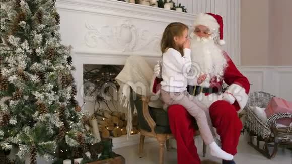 可爱的小女孩坐在圣诞老人的腿上描述他圣诞节她想要什么视频的预览图