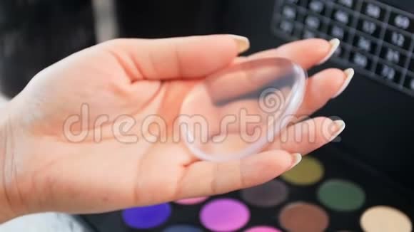 女性化妆师手持透明硅胶涂抹器化妆的特写慢镜头视频视频的预览图