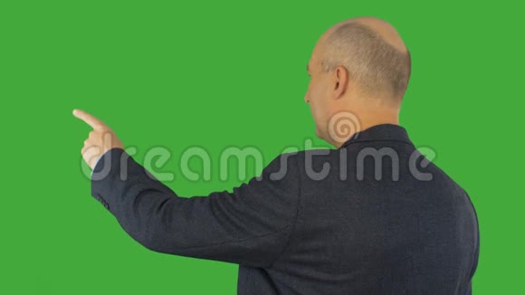 商人用食指指着绿色背景上的对话者或主题阿尔法频道键绿色视频的预览图