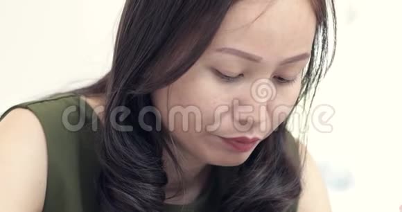 年轻的亚洲女人在餐馆的桌子上吃一碗面条视频的预览图