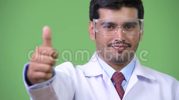 年轻英俊的波斯男医生戴着防护眼镜竖起大拇指视频的预览图