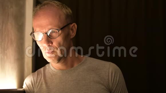 夜间思考时戴眼镜的成熟的斯堪的纳维亚人视频的预览图