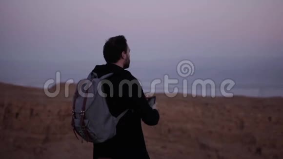 人类拍摄智能手机照片惊人的紫罗兰天空慢动作紫罗兰色的黄昏沙漠的山色大气的景色视频的预览图