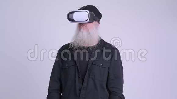 使用虚拟现实耳机的成熟胡须时尚男士视频的预览图