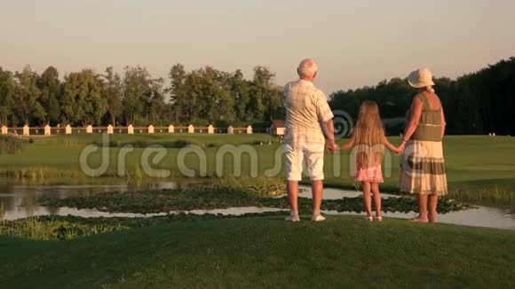祖父母带着孙女走在水边视频的预览图