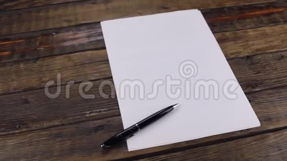 旋转一支笔躺在白纸上有一个地方供你的文字视频的预览图
