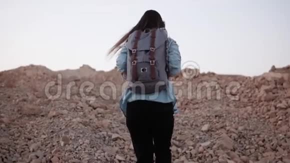 女人在陡峭的岩石山上远足慢动作旅游女孩用大石头爬山很难到达顶端视频的预览图