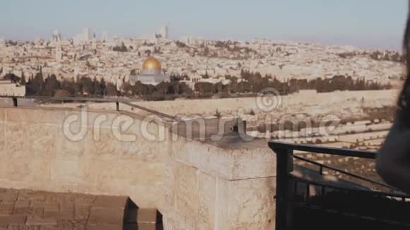 快乐的白种人女孩跑手臂张开观以色列耶路撒冷老城令人兴奋的女游客慢动作视频的预览图