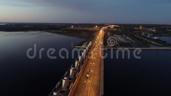 汽车行驶在突出的公路桥上从和海岸与工业轮胎在夕阳黄昏视频的预览图