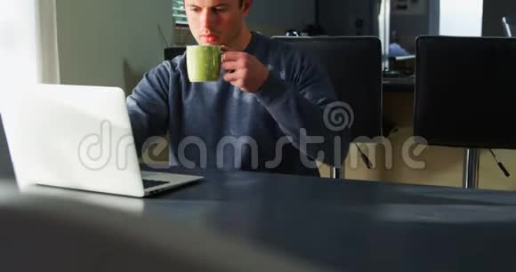 残疾人在使用笔记本电脑4k时喝咖啡视频的预览图