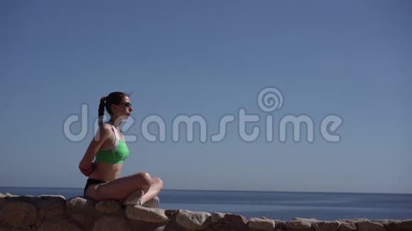 年轻苗条的模特在海边做瑜伽视频的预览图