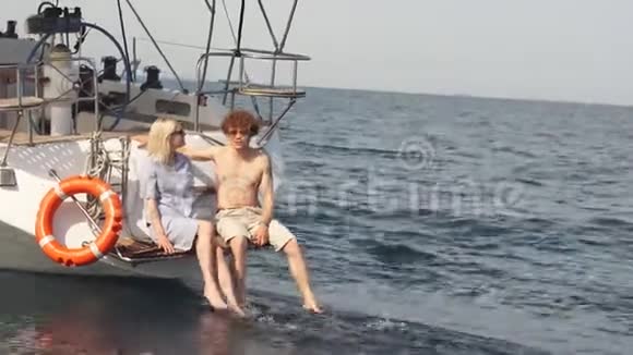 可爱的夫妇躺在海上游艇上在海滨度假视频的预览图