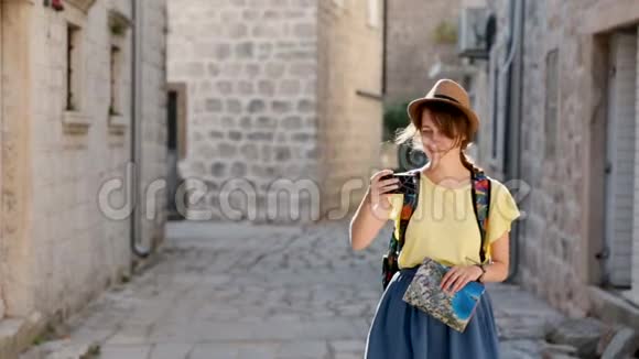 开朗的女游客戴着帽子在现代手机设备上拍一张照片走在街上积极的潮人视频的预览图