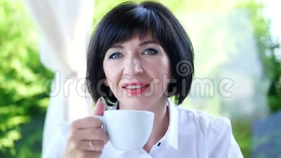 愉快微笑的肖像快乐美丽的真实40岁的乌克兰女人一个女人喝茶而不拿出视频的预览图