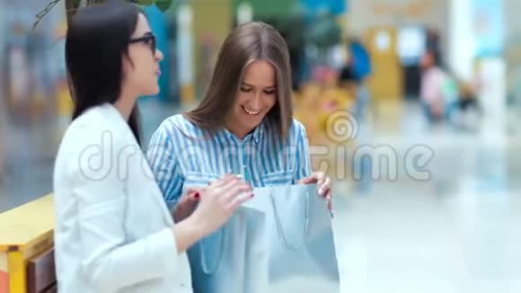两位美丽的年轻女士在商场购物后休息和讨论一些事情视频的预览图