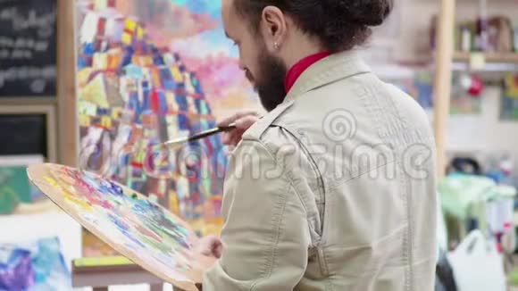 艺术家在画布上画一幅画站在画架后面艺术学院或绘画学校灵感天才视频的预览图